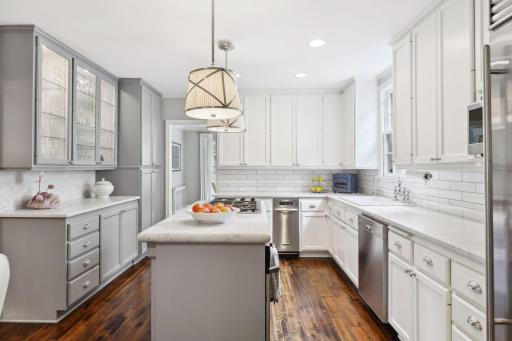 This beautiful custom kitchen features marble counter tops, a Sub Zero fridge, hand-scrapped walnut floors, custom faucet, and detailed backsplash.