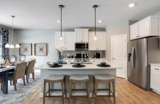 Quartz countertops, tile backsplash and spacious island. Stainless Whirlpool appliances with gas range and vented microwave, and dishwasher included. *Photo of decorated model home/same floor plan.