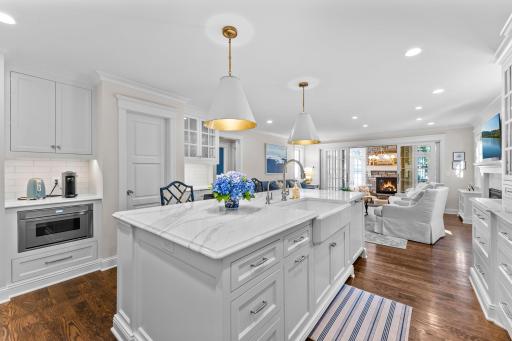 A view from the kitchen to the adjoining family room and to the four season sunroom beyond