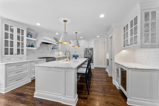 The kitchen includes a cooktop, double ovens, and a microwave