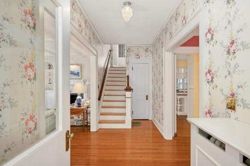 A spacious foyer and wooden staircase culminating in a carved newel post.