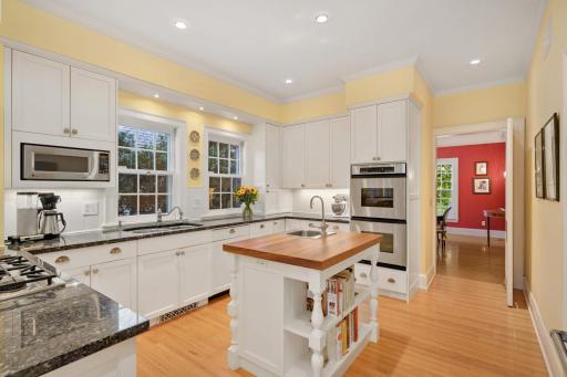 The center island includes a prep sink with disposal and counter space topped with burnished rich cherry wood