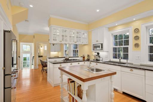 The remodeled Chefâs kitchen with a center island features custom-built enameled cabinets, granite countertops, stainless steel appliances, including a Dacor double oven, gas cooktop, and a KitchenAid 5-door refrigerator