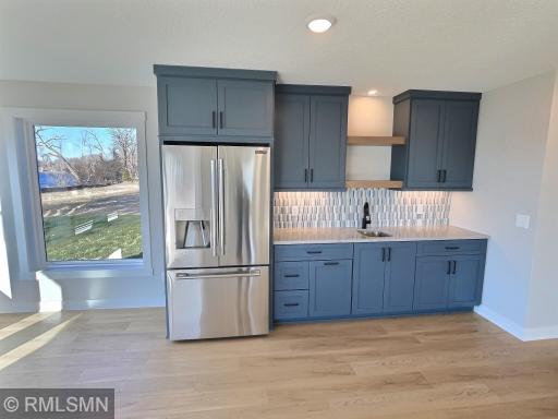 Featuring a fridge, custom cabinets with shelves, unique backsplash and sink...the wet bar is an amazing addition to the lower level.