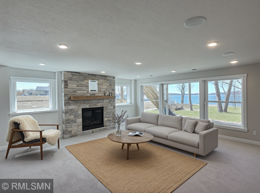VIRTUALLY ENHANCED PHOTO - Gather in a comfortable entertaining space with a patio door leading to the lakeside.