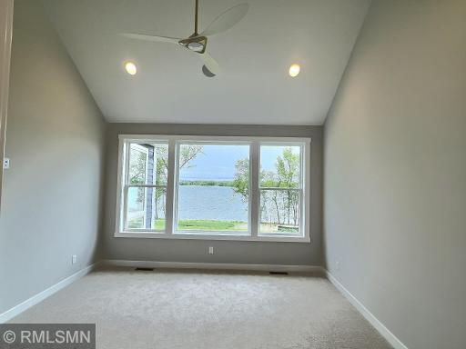 Complete with a ceiling fan, can lights, carpet and calming paint color, the primary suite is on the main level offering lake views.