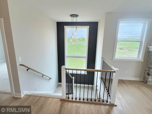 View of the welcoming foyer with large front door and staircase with large inviting window and fun pendant lighting.