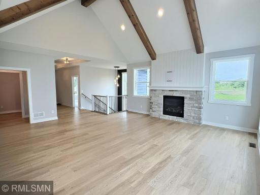 Complete with shiplap accents and stone around the fireplace and large ceiling beams, the living room is bright and spacious.