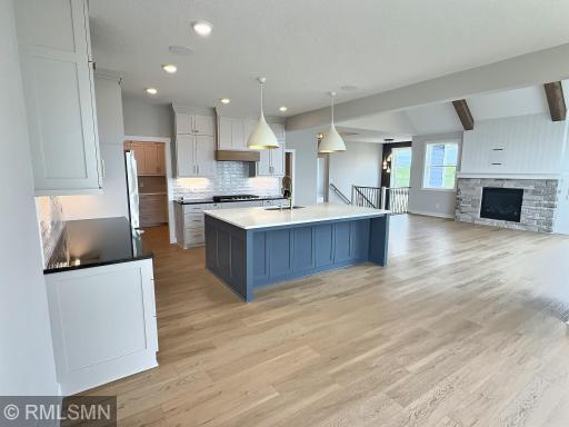 Wow! This is certainly a dream kitchen featuring a large center island, two-toned cabinets and beautiful quartz countertops.