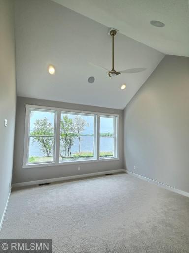Retreat after a long day spent on the lake to your primary master suite featuring high a vaulted ceiling and a wall of glass.