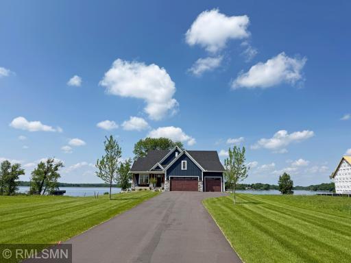 Absolutely stunning landscaping showcasing perennials and rock surrounds the home along with lush green grass.
