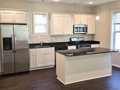 White kitchen with large island/brkfast bar.