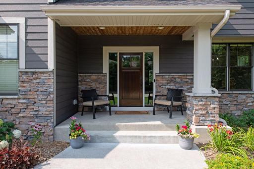Welcome to your dream home, nestled behind professionally manicured landscaping and showcasing elegant stone accents. As you approach, the charming covered porch invites you in.