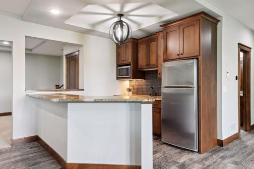 The family room's built-ins complement the dark wood of the bar, which includes a full refrigerator.
