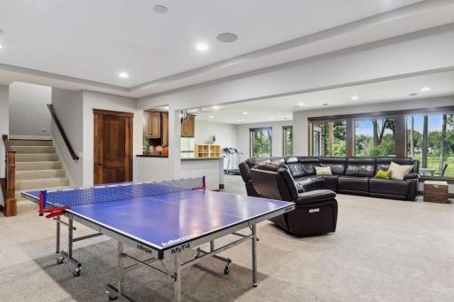 A gaming area, family room, bar, and a flexible space currently used as a home gym.