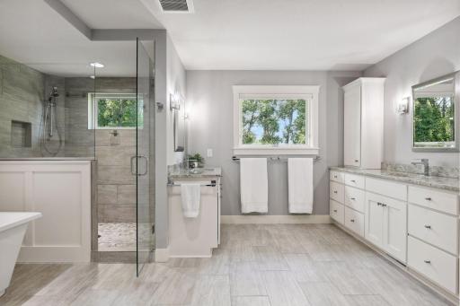 The primary bathroom features dual sinks, large soaking tub, and tiled shower.