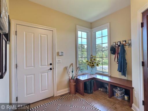 As you enter from the garage you will find extra space to set your things, or gather as you leave. Nice bench and hooks to keep your things.