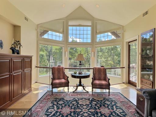 Extraordinary windows bring gorgeous views in a very private setting. Living room with overlook to the lower level. Electric blinds make for easy adjustments.