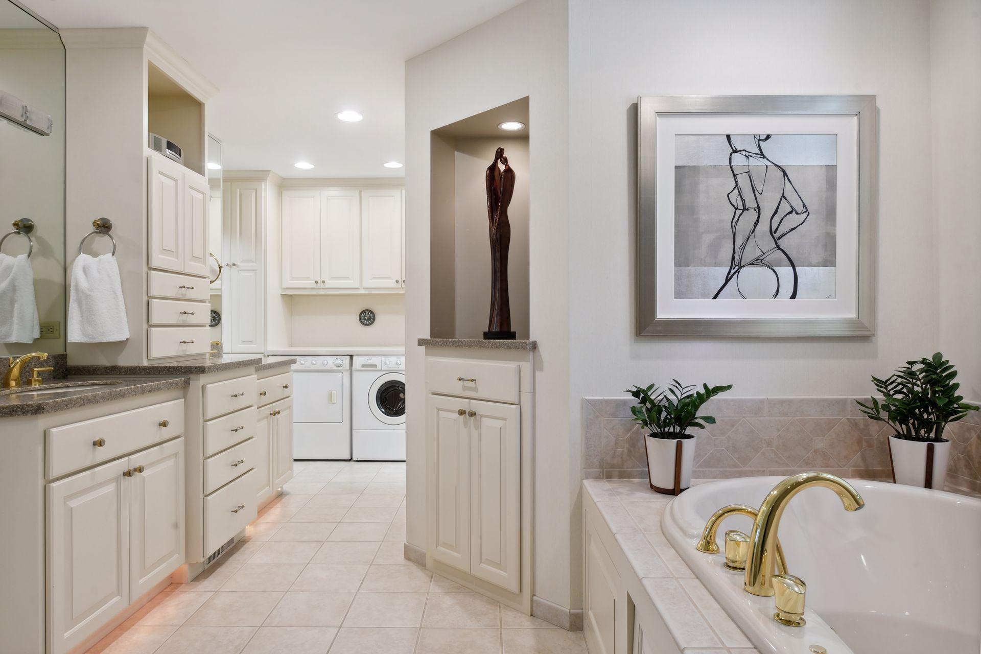 Primary bathroom with separate tub and shower, laundry, and dual closets.