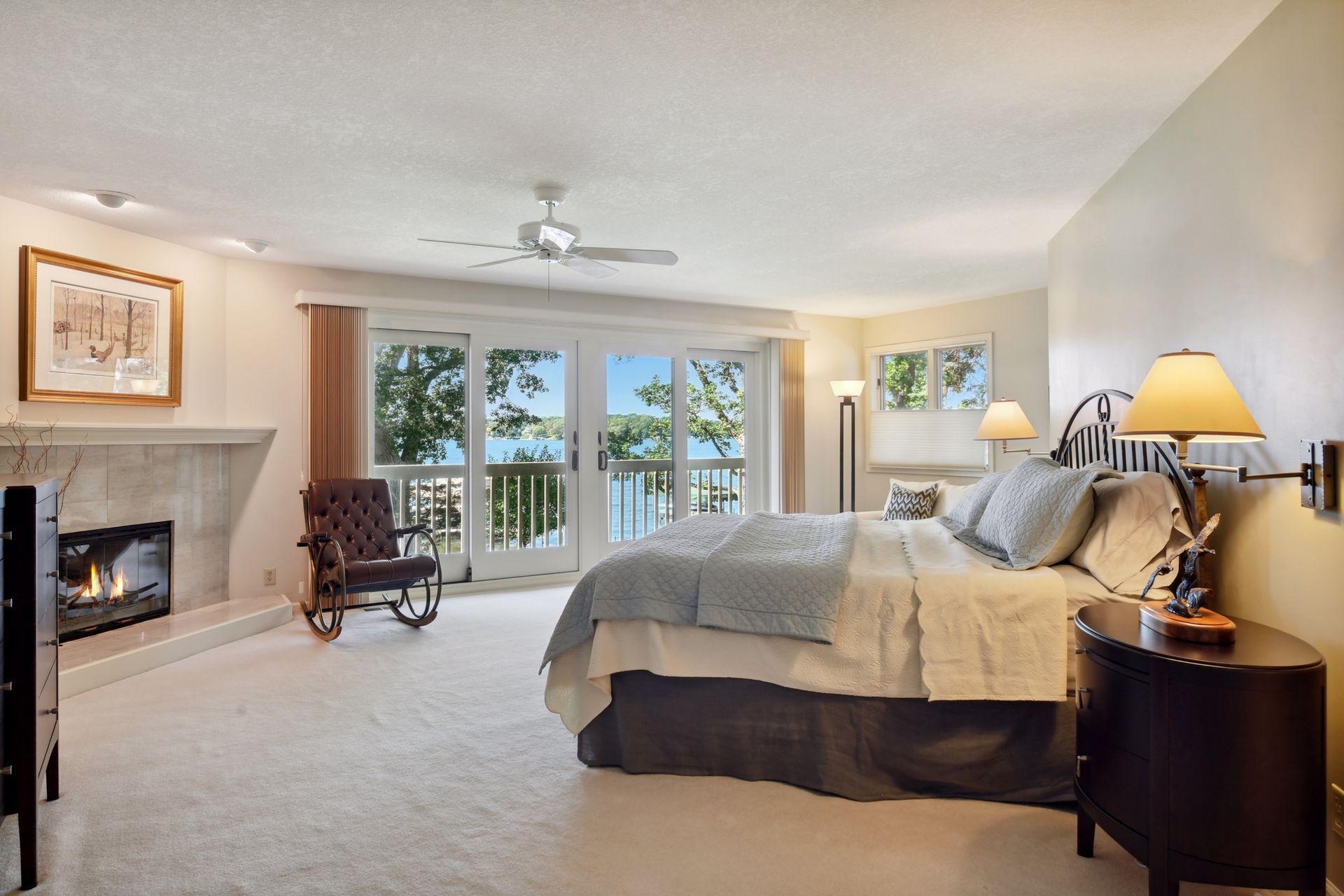 The primary bedroom suite with wonderful lake views, gas fireplace and a balcony.