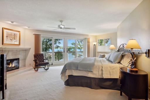 The primary bedroom suite with wonderful lake views, gas fireplace and a balcony.