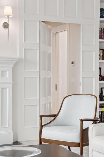 The panel next to the book shelves pushes open to private access to the primary suite.