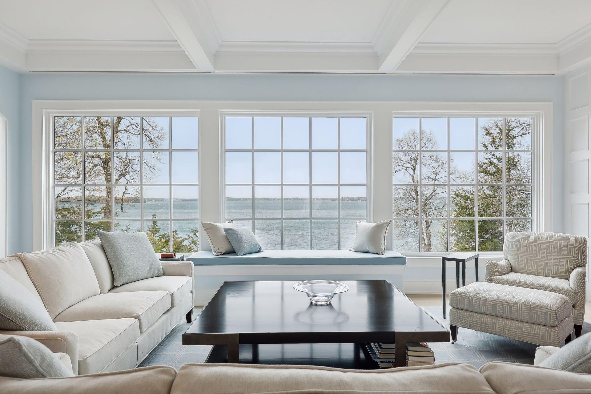 Living room with gorgeous lake views! There is a Pop-up TV under the cushions and automatic shades.