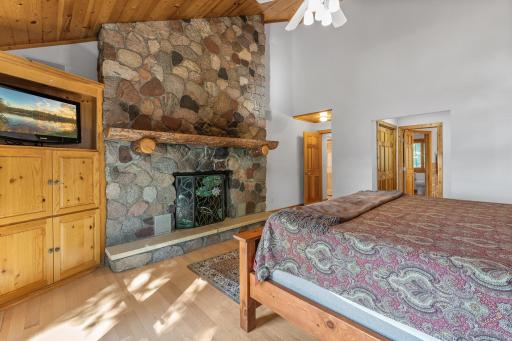 Double Sided Gas Fireplace with Stone Wall and Timber Mantel