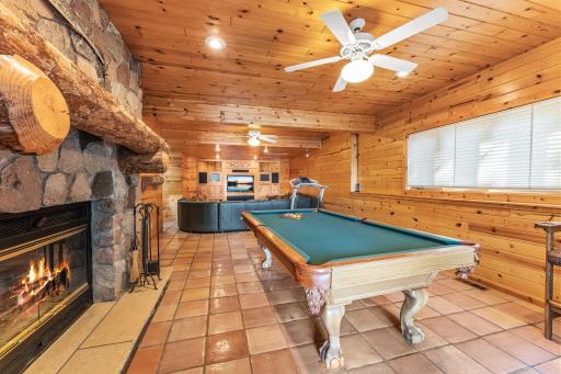 Wood Burning Fireplace with a Stone Wall and Timber Mantel