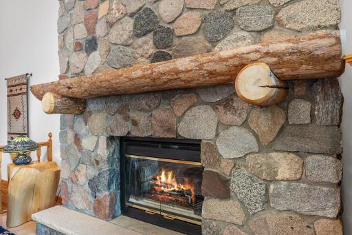 Double Sided Gas Fireplace with Stonewall and Timber Mantle