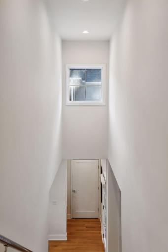A dramatic straight staircase leads up to the bedroom level.