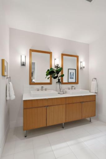 Large primary bath with double vanity, storage, recessed medicine cabinets, and a walk-in shower.