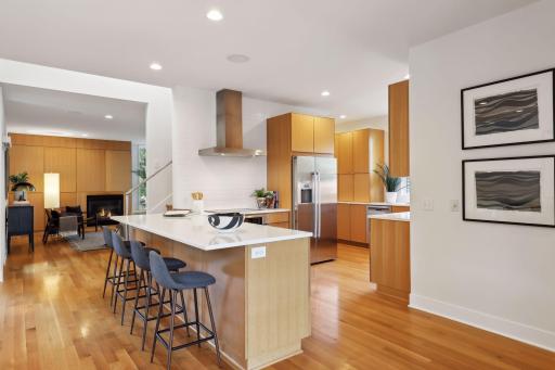 Seating for four at the kitchen island with quartz countertops and plenty of space for serving and preparing meals.