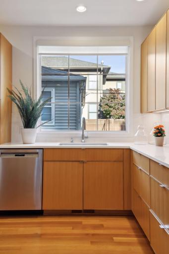 A thoughtful kitchen design with a large kitchen sink window, a dedicated coffee bar and appliance cupboard, and excellent storage.