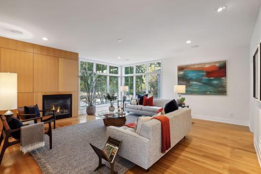 Spacious living room with a corner of oversized windows providing abundant natural light and pretty front yard views. Rift-sawn white oak floors and cabinetry throughout the home on all three levels!