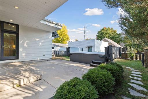 The back yard features a spacious patio, fenced-in yard with irrigation, grassy areas, stone paver path, and an included spa fitness pool that can be used year-round!