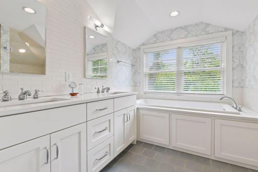 Primary bathroom ensuite with double vanity, tile floor and natural light