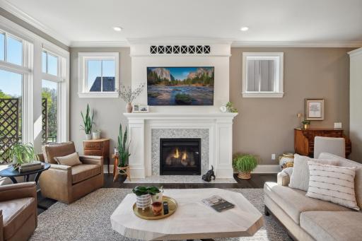 The gas burning fireplace creates a cozy ambience while windows flood the family room with light
