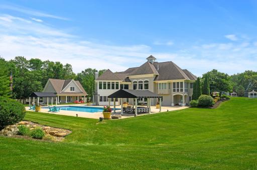 The outdoor space is a true haven, featuring an impressive stamped concrete patio that surrounds the 60x30 in-ground heated saltwater pool.