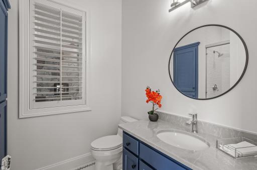 The lower level mudroom is perfect for those enjoying the pool. It provides access to a well-appointed three-quarter bathroom with beautiful penny tile floors and a walk-in shower stall.