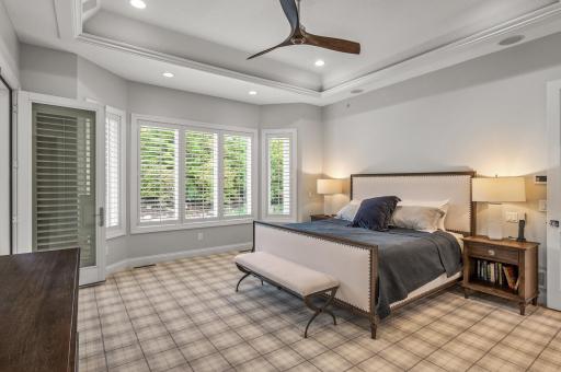 The primary ensuite is a sanctuary within the home, offering a private screened porch, a deluxe walk-in closet with extensive built-ins, and a lavish private bath.