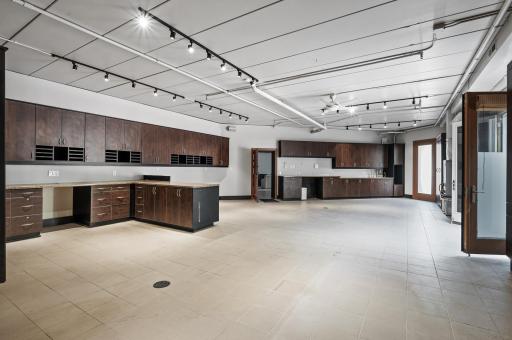 Discover a large storage space beneath the garage, thoughtfully designed with an abundance of built-in cabinets and counter space. It also offers convenient access to the backyard.