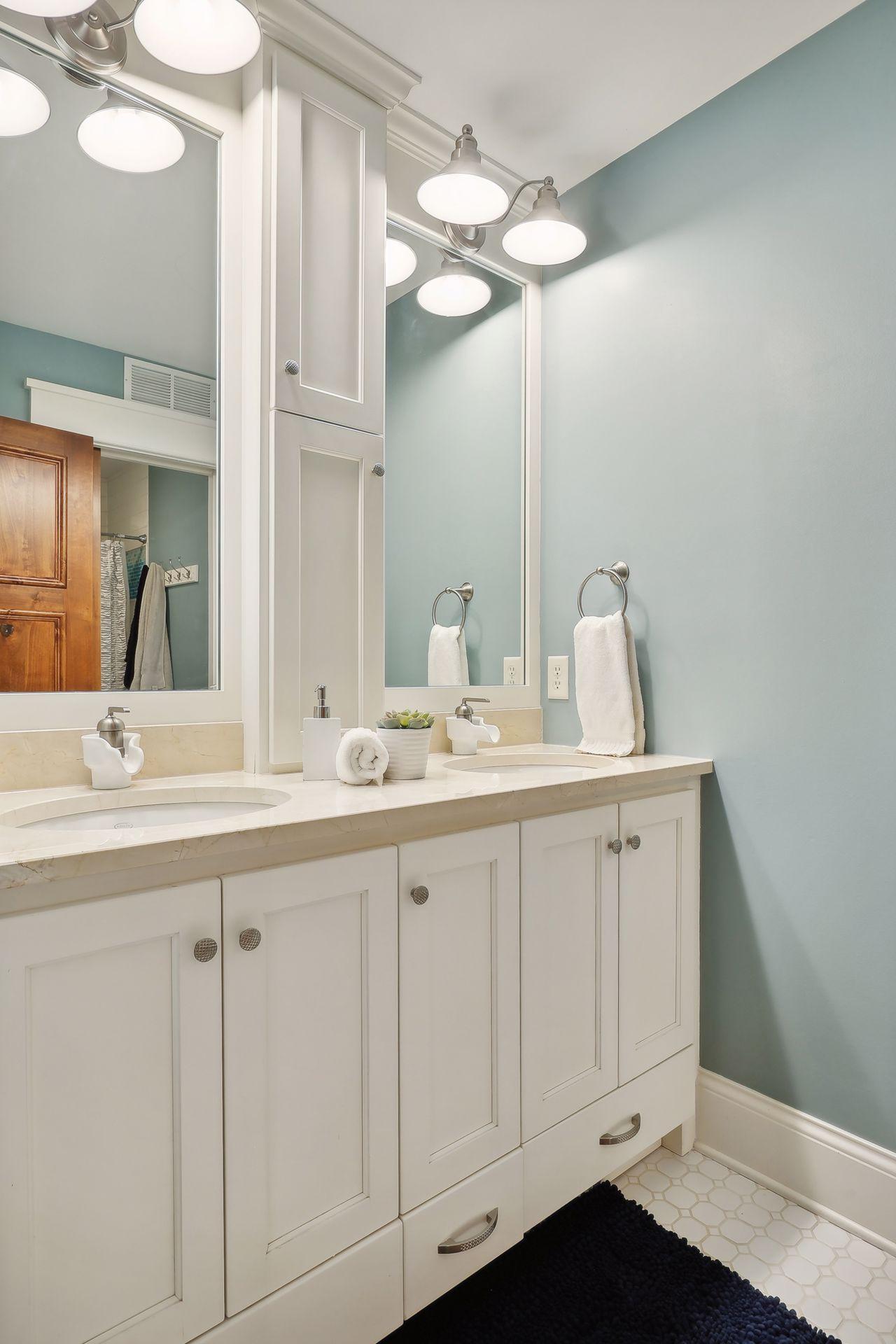 The full hall bathroom features a comfort-height vanity with two sinks and a separate water closet with a tiled bathtub/shower surround. Each bathroom enjoys heated tile flooring.