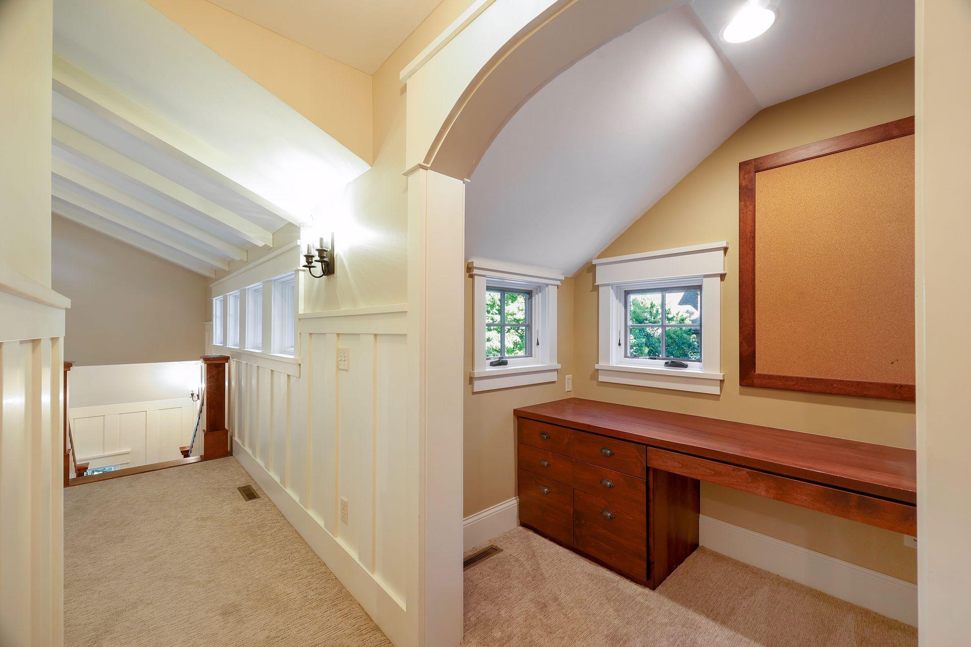 Nestled under a curved archway is the upper level Homework Nook that features built-in desk and bookcases - perfect for studying and keeping all the school work organized.