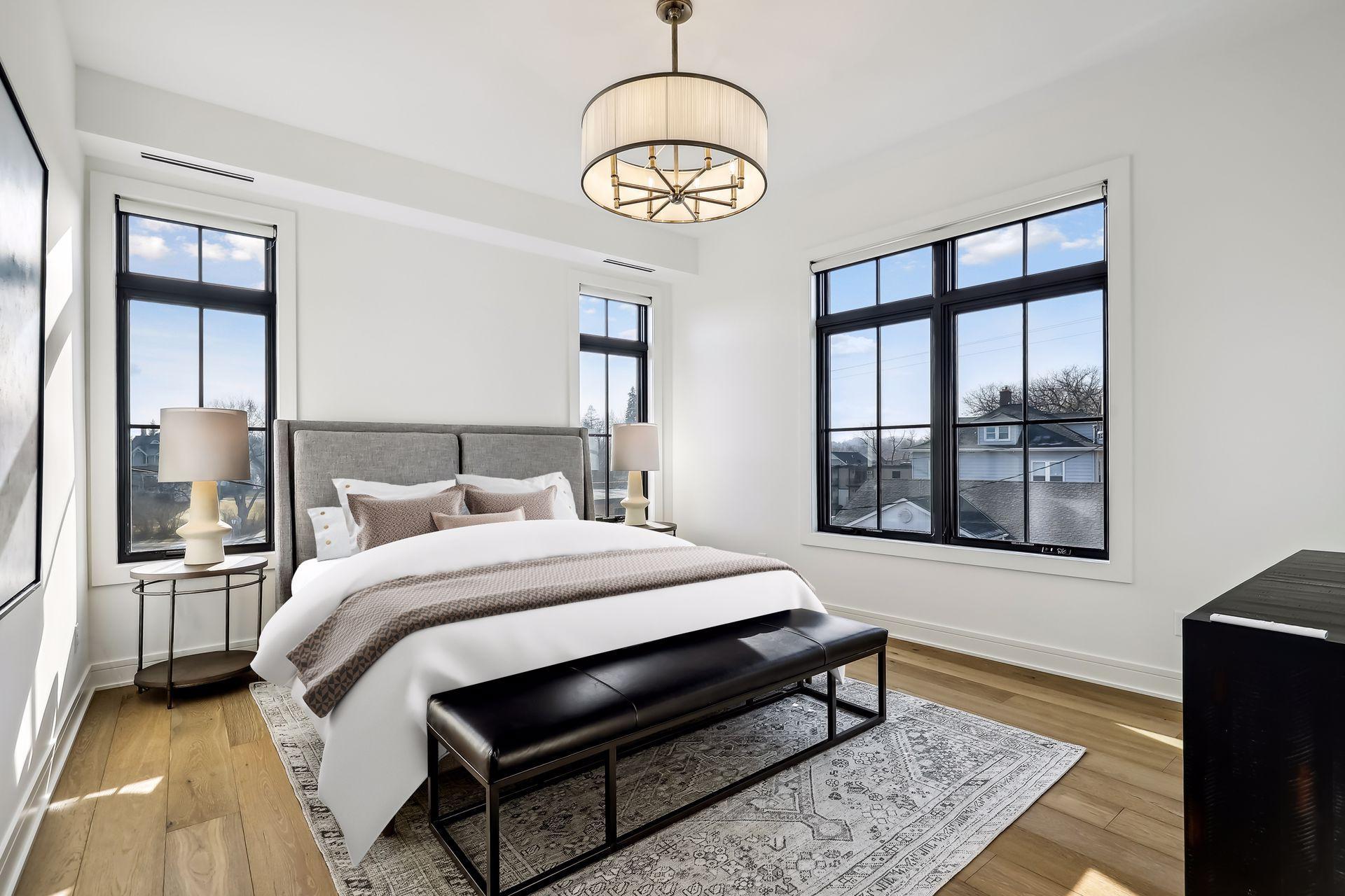Multiple windows in the primary bedroom fill the space with light