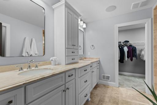 Primary bathroom includes double vanity, tile floors & walks through to the walk-in closet