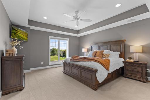 Primary bedroom with tray ceiling detail offers a wonderful private retreat and includes his & hers closets