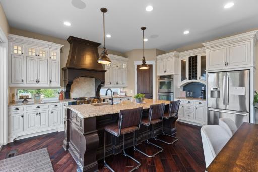 The gourmet kitchen is a chef's dream! Enjoy a large center island with breakfast seating, double ovens, stainless appliances, gas range, wine rack, custom cabinetry & windows offering a great addition of extra natural light