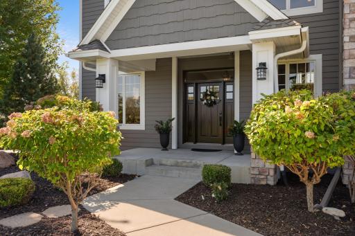 The front entry welcomes you in, surrounded by beautiful landscaping