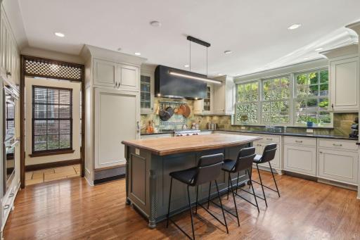 Tiled backsplash throughout kitchen. Large exhaust hood.
